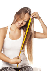 beautiful girl measured her hair with a measuring tape