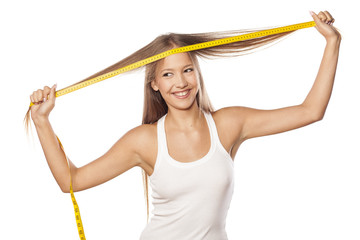 beautiful girl measured her hair with a measuring tape
