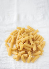 Pasta penne on white cloth background