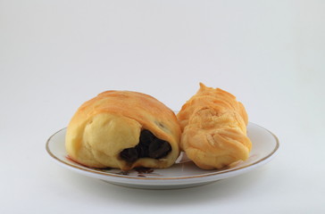 Raisin bread and two eclair on the dish