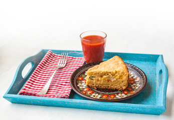 Portion of oat flour cake and mug  of tomato juice on a tray
