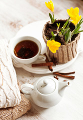 Cup of hot drink, knitting clothes, cinnamon and flowers. winter