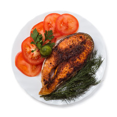 Baked trout with vegetables on a white background