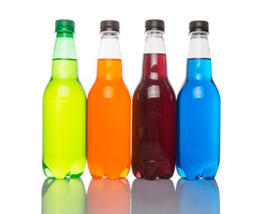 Multicolored soda drinks in bottles over white background