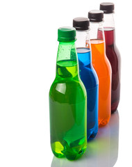 Multicolored soda drinks in bottles over white background