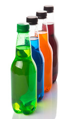 Multicolored soda drinks in bottles over white background