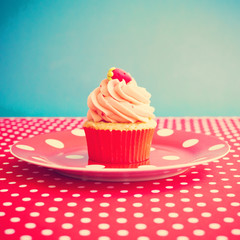 Strawberry cupcake over polka dots tablecloth