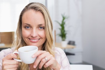 Businesswoman holding coffee mug and smiling