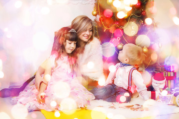 Fototapeta na wymiar Happy mother and two her children in Christmas