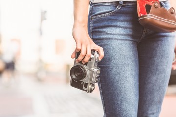 Close up of a girl wearing jean and holding a camera