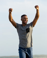 Man celebrating success with arms raised