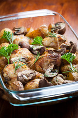 Baked chicken on potatoes and mushrooms