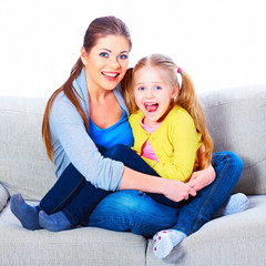 Mother with daughter sitting on sofa with embrace