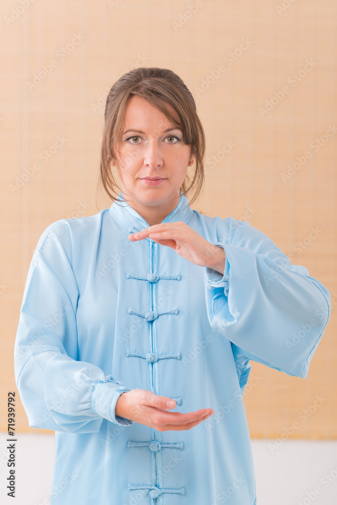 Wall mural Woman doing qi gong tai chi exercise