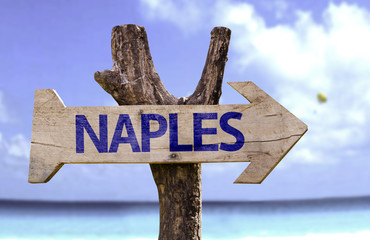 Naples wooden sign with a beach on background