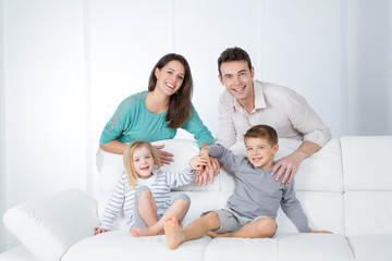cheerful family on white sofa
