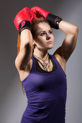 Portrait of beautiful girl with red boxing gloves, looking up