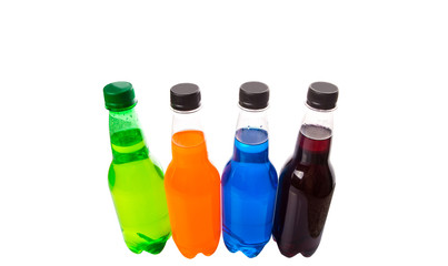 Multicolored soda drinks in bottles over white background