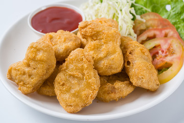 Chicken nuggets on a plate with sauce and vegetables on the plat