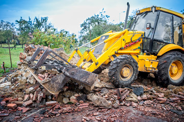 bulldozer working at demolition site, cleaning debris of bricks