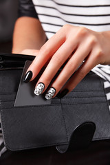 Fototapeta premium Beautiful painted nails holding a credit card