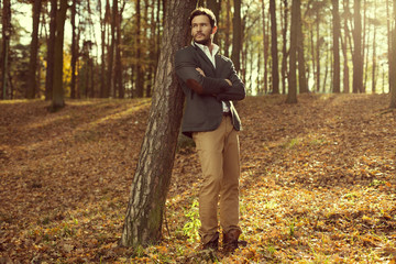 Handsome man in the park. Autumn scenery
