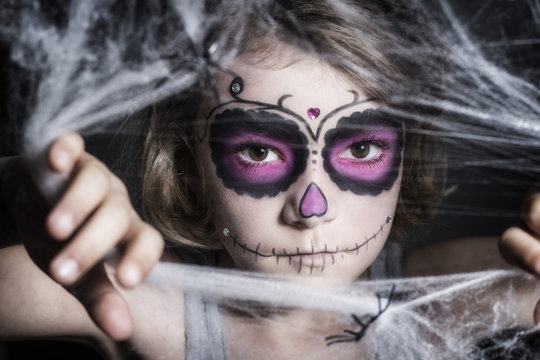 kleines M&auml;dchen mit Sugar Skull Make up, hinter Spinnweben