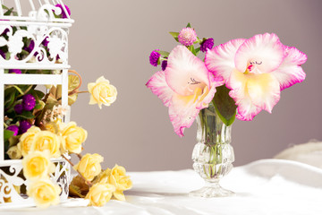 Fototapeta na wymiar Orchids in glass vase and roses.