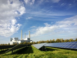 Solaranlage und Heizkraftwerk unter blauem Himmel