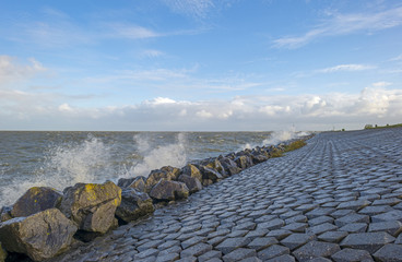 Basalt stones along a dike in a stormy sea