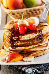 Pancakes with chocolate sauce fruit and glass of milk