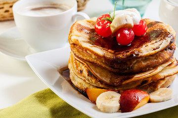 Pancakes with chocolate sauce fruit and coffee