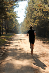 Barefoot runner running through autumn forest