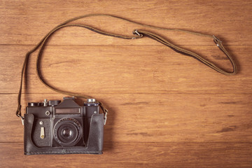 Vintage camera on wooden table. Instagram style toned photo.