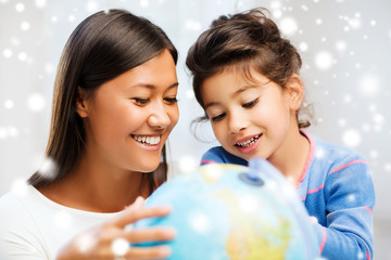 mother and daughter with globe indoors