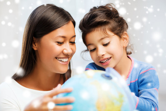 mother and daughter with globe indoors