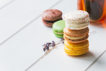 Macarons stack with tea on white wooden background