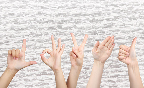Young people's hands on grey background