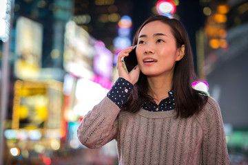 Young Asian Woman talking on cellphone at night