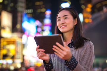 Young Asian Woman using tablet pc at night