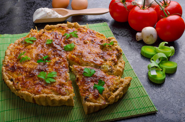 Home French quiche stuffed with mushrooms, tomato and leek