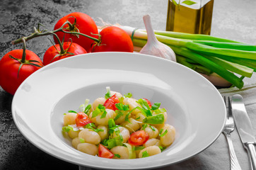 Vegetarian gnocchi with spring onions and tomatoes