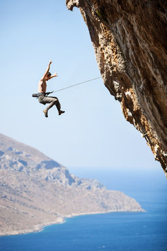 Rock climber falling of a cliff while lead climbing