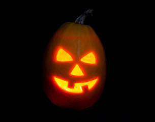 Halloween pumpkin jack-o-lantern candle lit, isolated on black