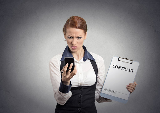 skeptical businesswoman holding contract looking on smartphone