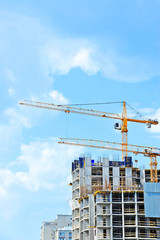 Crane and building construction site against blue sky