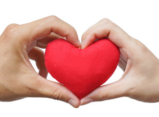 man's hand and woman's hand holding a red heart