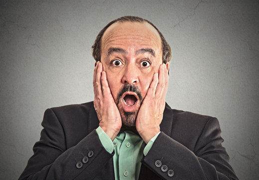 Surprise astonished guy isolated on grey wall background 