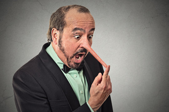 Liar man with long nose isolated on grey wall background 