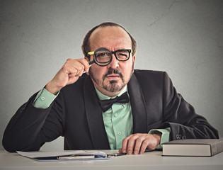 businessman skeptically looking at you through magnifying glass